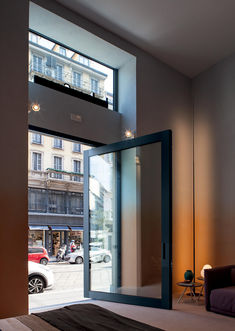 a bedroom with an open glass door leading to a parking lot in front of it