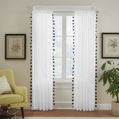 a living room with white curtains and black trim