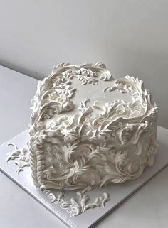 a white cake sitting on top of a table covered in frosting and icing