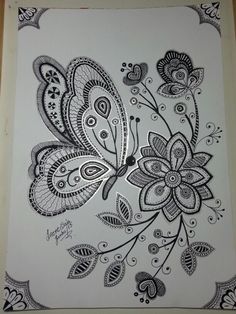 a drawing of a butterfly on paper with black and white flowers in the middle,