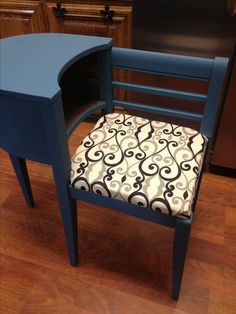 a blue chair with a black and white patterned seat pad sitting on top of a hard wood floor