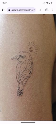 a small bird tattoo on the back of a woman's thigh, which is drawn in black ink