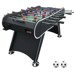 an image of a foosball table with two soccer balls on the side and one ball laying next to it