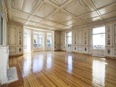 an empty room with wooden floors and white walls