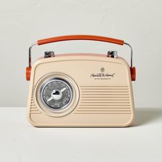 an old fashioned radio sitting on top of a white table next to a red handle