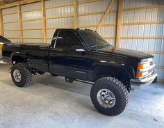 a large black truck parked in a garage