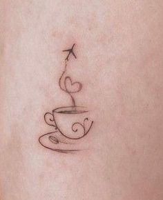 a small tattoo on the back of a woman's leg with a coffee cup