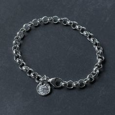 Enhance your style with this elegant sterling silver rolo tag bracelet. Boasting a 6.3mm belcher bracelet and classic design, this bracelet is minimal yet bold. Perfectly paired with a reticulated round tag, this bracelet will add a touch of sophistication to any look. Details: Chain: Sterling Silver Rolo Chain, 6.3mm Clasp: Sterling Silver Lobster claw clasp Sizes: 6" to 9” Full and half sizes Shipping: Ready to ship within one business day Complimentary shipping in the USA Complimentary gift w Tarnish Resistant Silver Oval Link Charm Bracelet, Sterling Silver Cable Chain Bracelets, Sterling Silver Cable Chain Bracelet, Chunky Bracelet, Coin Bracelet, Round Tags, Organic Design, Rolo Chain, Lobster Claw