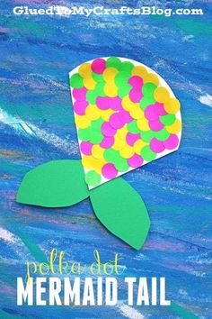 a paper flower made out of colored confetti on top of blue water with the words mermaid tail