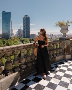 a woman standing on top of a building next to a black and white checkered floor