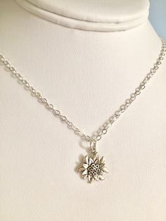 "Charming little Sterling silver Edelweiss flower necklace featuring detailed Sterling wildflower of Austrian folklore suspended from sparkling Sterling silver cable chain. The Edelweiss flower is a cherished symbol in Austria and Switzerland and prominent in folklore. Lovely little white flower grows high in the Alps and has always represented love, purity and nobility. This beautiful Sterling silver charm is 5/8\" x 3/4\" and has a flat back. Hangs from .925 Sterling silver flat cable chain wi Edelweiss Flower, Silver Flats, The Alps, Emerald Earrings, Emerald Gemstone, Pink Earrings, Necklace Sterling Silver, White Flower, Flower Necklace