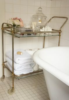 a bathroom with a bathtub, sink and towel rack in the middle of it