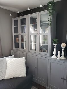 a living room with gray furniture and white pillows