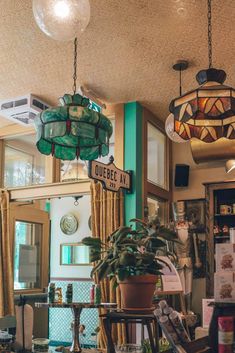 the interior of a restaurant with hanging lights and potted plants