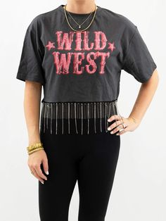 Our wild west crop top is a prime choice or your next concert outfit or for a weekend trip to Nashville. This tee is available in gray, with "Wild West" written in pink, large font. The rhinestone fringe along the bottom of the tee adds the perfect touch of glam. SIZE & FIT Fit is true to size The model is 5'6" and wearing a size small Fringe Shirts, Rhinestone Crop Top, Fringe Shirt, Large Font, Rhinestone Fringe, Weekend Trip, Weekend Trips, Wild West, Concert Outfit