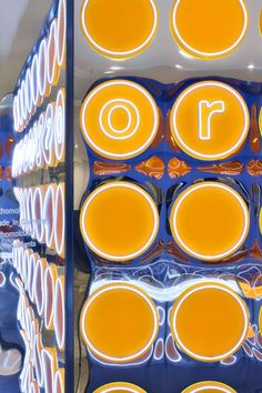 an array of orange and white circles are on display in a store window with the letter o