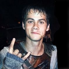 a young man making the peace sign with his fingers