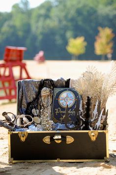 an open suitcase sitting on top of a sandy beach