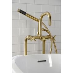 a gold faucet and sink in a bathroom with white tile wall behind it