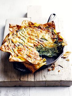 a casserole dish on a wooden cutting board