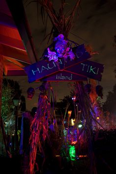 there is a sign that says hacha tiki island in front of some plants