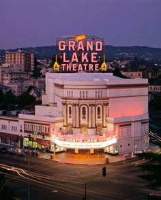 the grand lake theatre is lit up at night with lights on it's roof