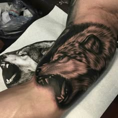 a man with a wolf tattoo on his arm next to another person's foot