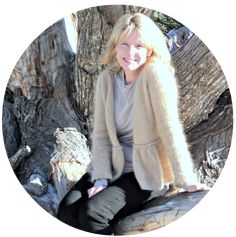 a woman sitting on top of a tree branch