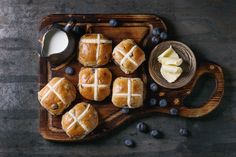 hot cross buns with butter and blueberries on a cutting board