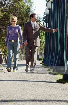 a man and woman walking down a sidewalk