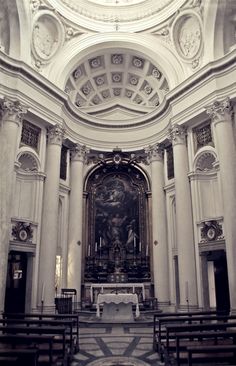 the inside of a church with pews and an ornately decorated ceiling above it