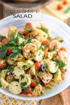 a white bowl filled with shrimp salad on top of a wooden table