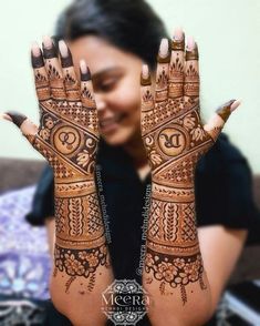 a woman holding her hands up to show the hendi design on her hand and face