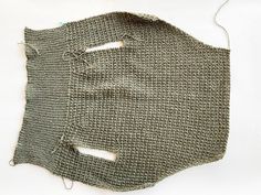 a piece of knitted material with holes cut out from the side and thread in between