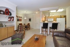 a living room filled with furniture next to a kitchen