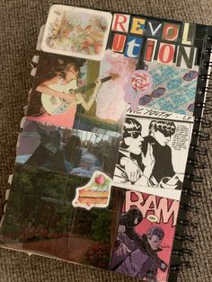 an open notebook with various pictures and stickers on the cover, sitting on a carpet