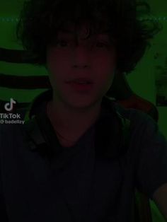 a young man wearing headphones in front of a neon green background with the words tik tok on it