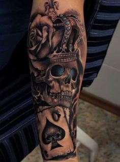 a man's arm with a skull and roses tattoo on the side of his leg