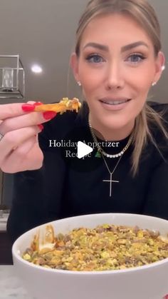 a woman is holding a piece of pizza in front of her face