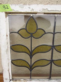 an old stained glass window with leaves on it