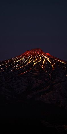 the top of a mountain lit up at night with lights on it's sides