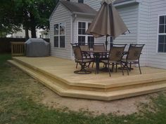 a deck with an umbrella and chairs on it