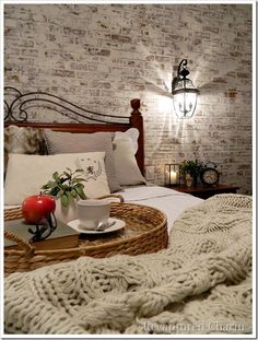 a bed with a basket on top of it next to a night stand and lamp