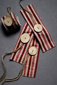 two red and white striped bags with wooden buttons on them, tied to twine