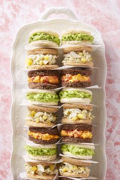 several sandwiches are stacked on top of each other with different toppings in the middle