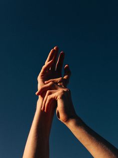 two hands reaching up into the sky