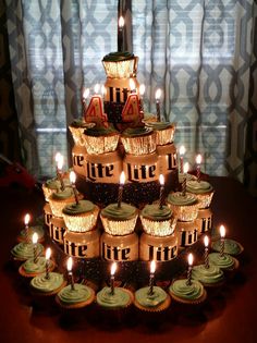 cupcakes are stacked on top of each other with lit candles in the middle