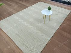 a white table sitting on top of a wooden floor next to a chair and rug