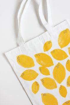 a white bag with yellow lemons painted on it