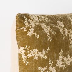 a brown and white pillow with flowers on it